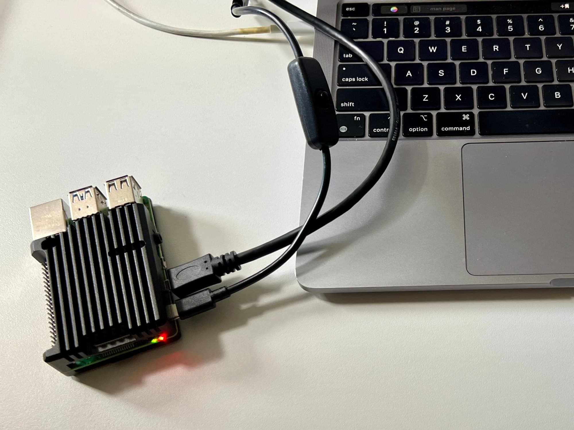 Raspberry Pi 4 in a black heatsink case, connected to a MacBook for testing