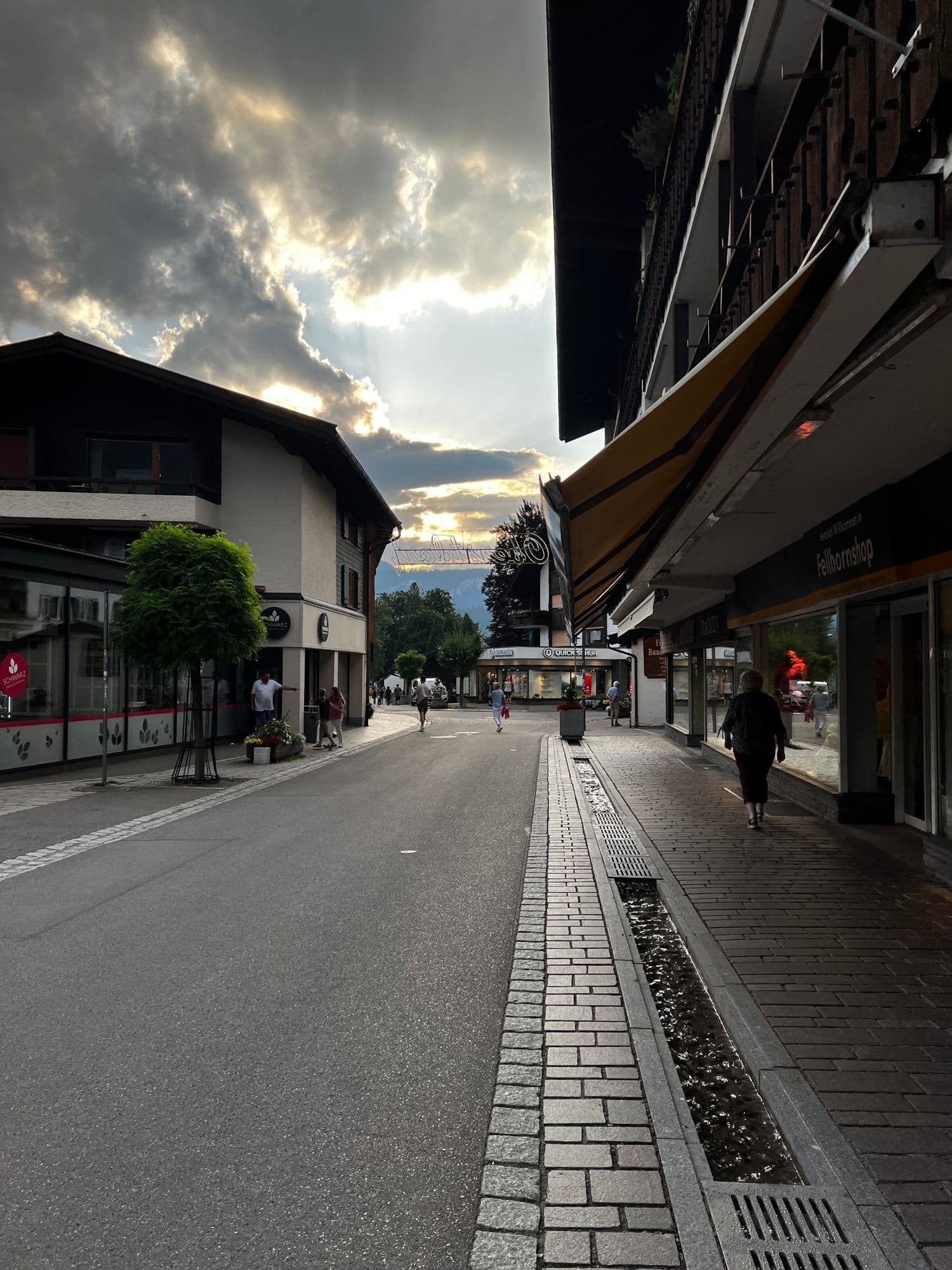 Oberstdorf's main street at sunset with light breaking through the clouds