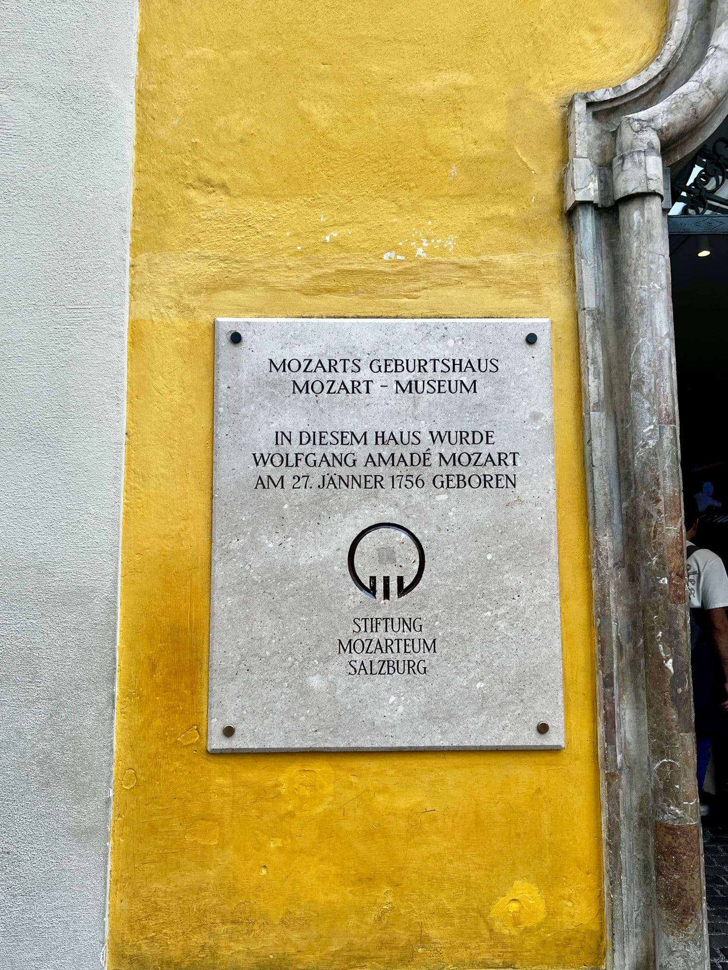 Stone plaque on the yellow wall of Mozart's birthplace