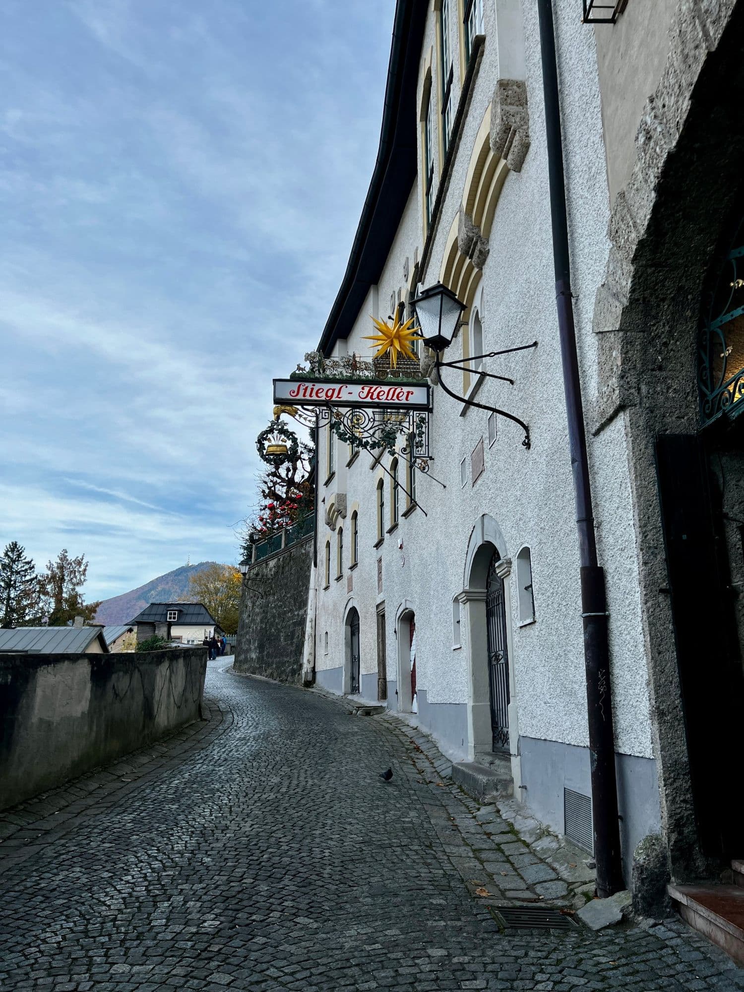Cobbled lane curving past the Stiegl-Keller sign